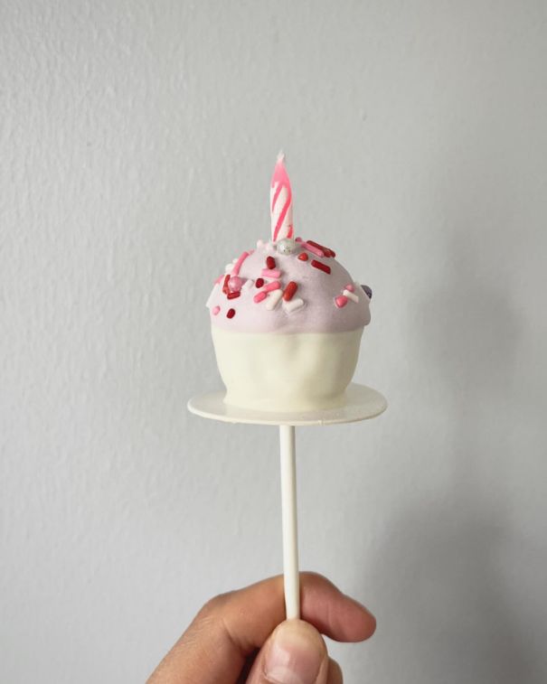 Sweet Natalia pink-and-white birthday cake pop with sprinkles and a candle