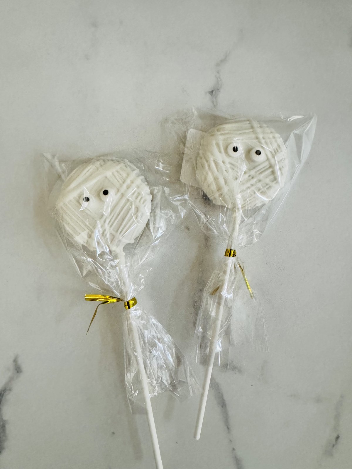 Two mummy cake pops with candy eyes